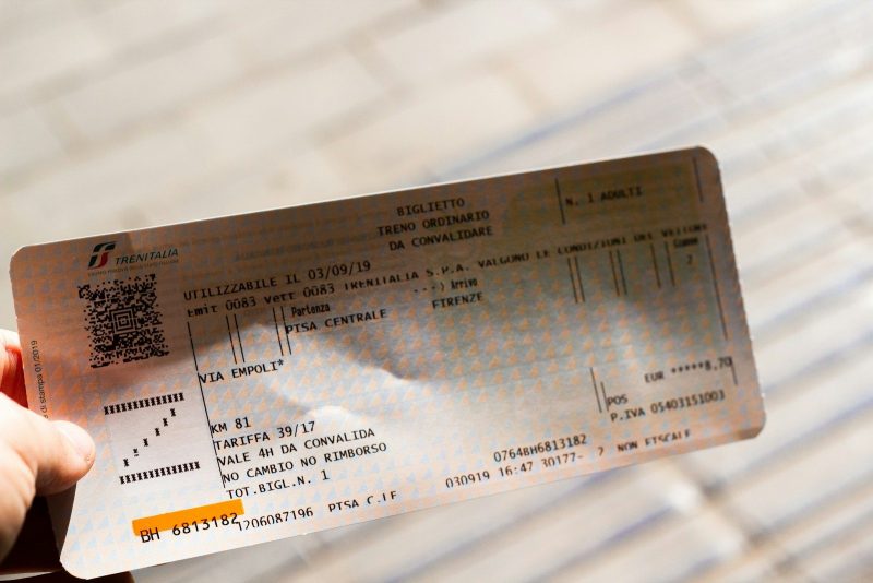 A person holding up a ticket for a concert